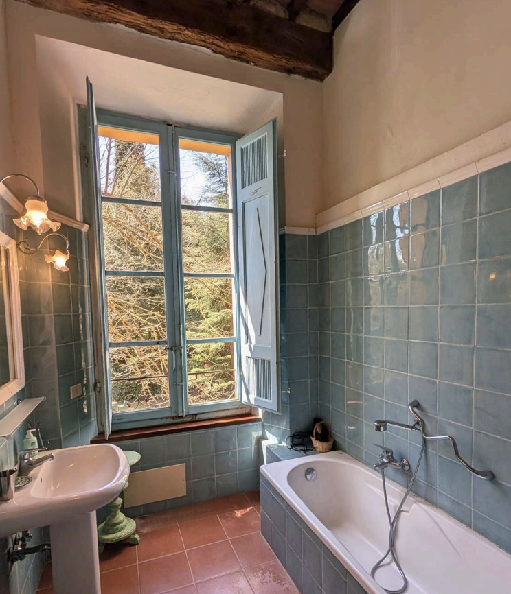 Bright Tuscan bathroom with large window and natural light at Castello Higo luxury yoga and wellness retreat in Italy