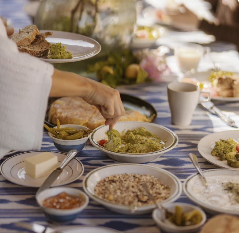 Finca Higo brunch table with vegan dishes, healthy dips, and fresh bread prepared for yoga retreat participants.