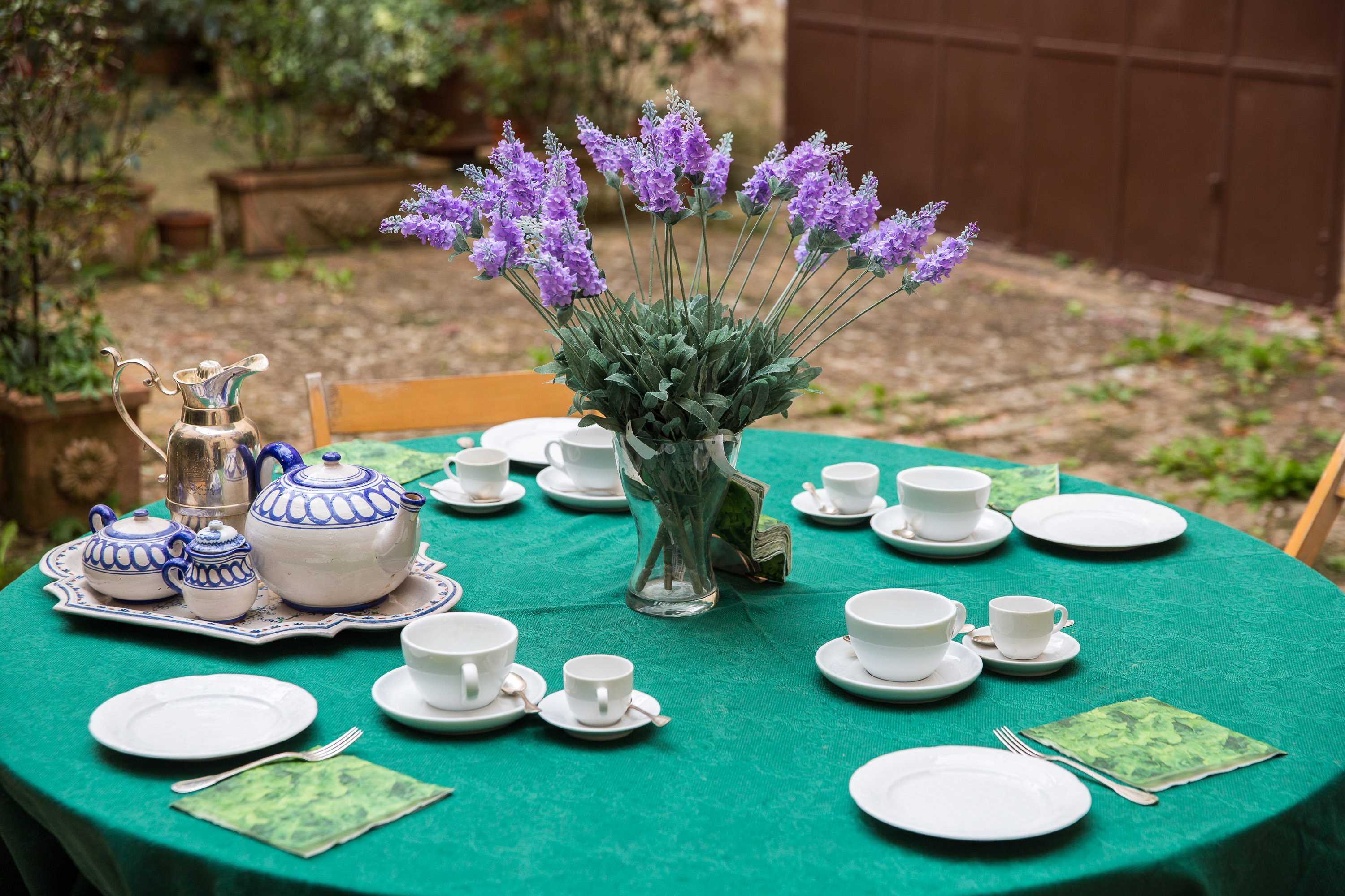Elegant outdoor dining table with lavender centerpiece and ceramic tableware at Castello Higo, a luxury yoga and Pilates retreat center in Tuscany, Italy