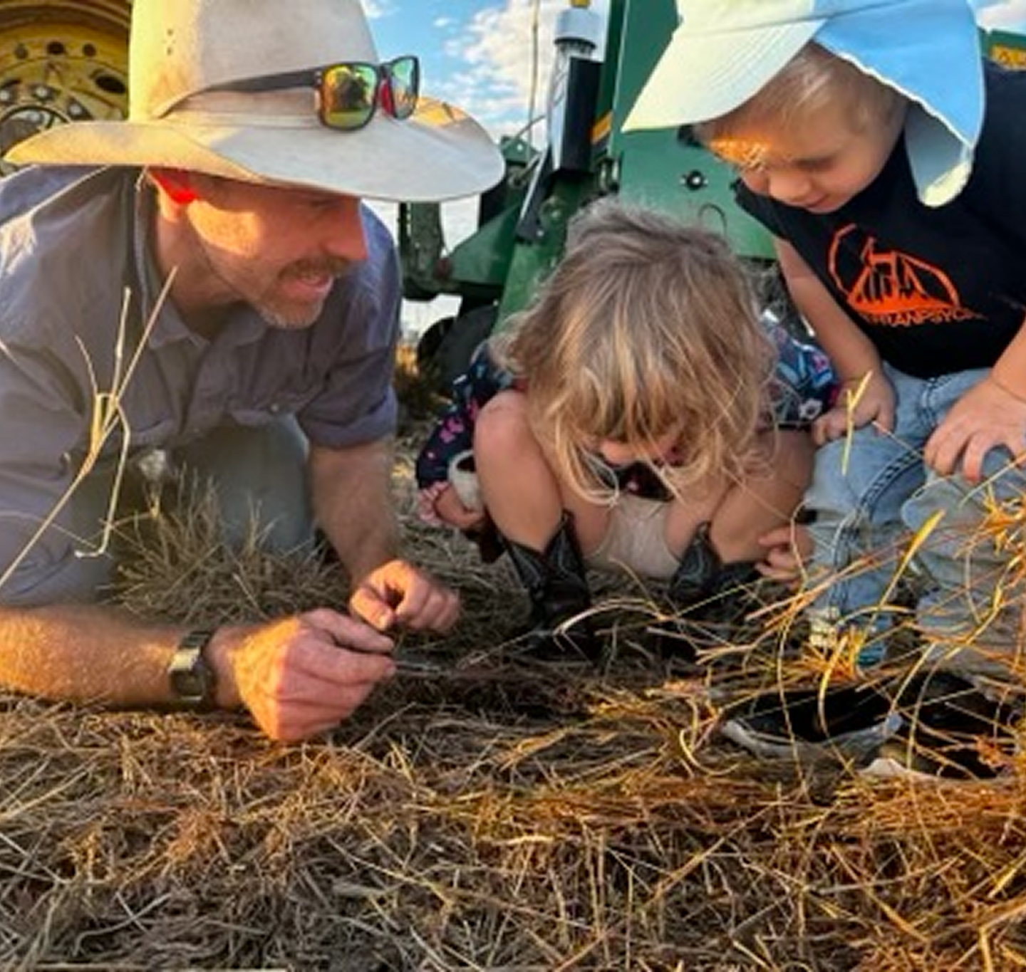 The owner Adam points out something on the ground to his children