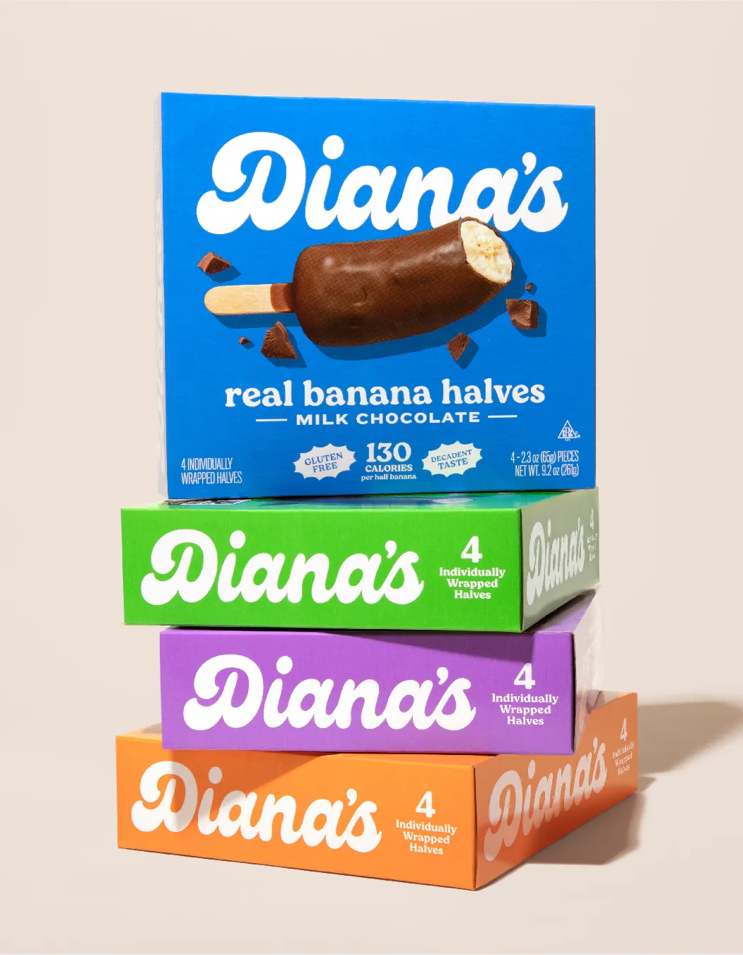 Stack of four Diana's boxes (blue Milk Chocolate on top) on a beige surface.