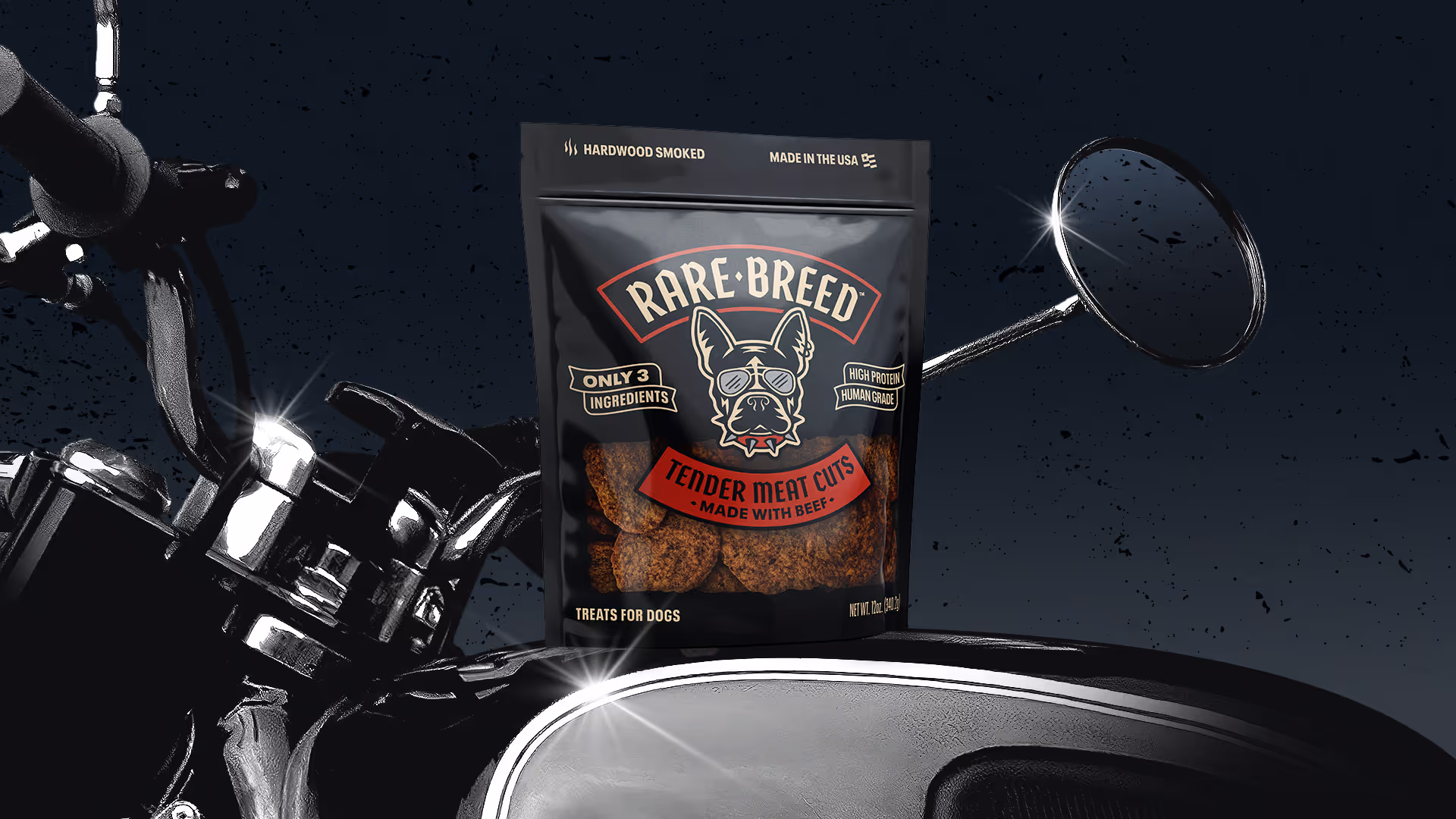 Black Rare Breed Tender Meat Cuts treat pouch propped on a motorcycle's gas tank with chrome handlebars.