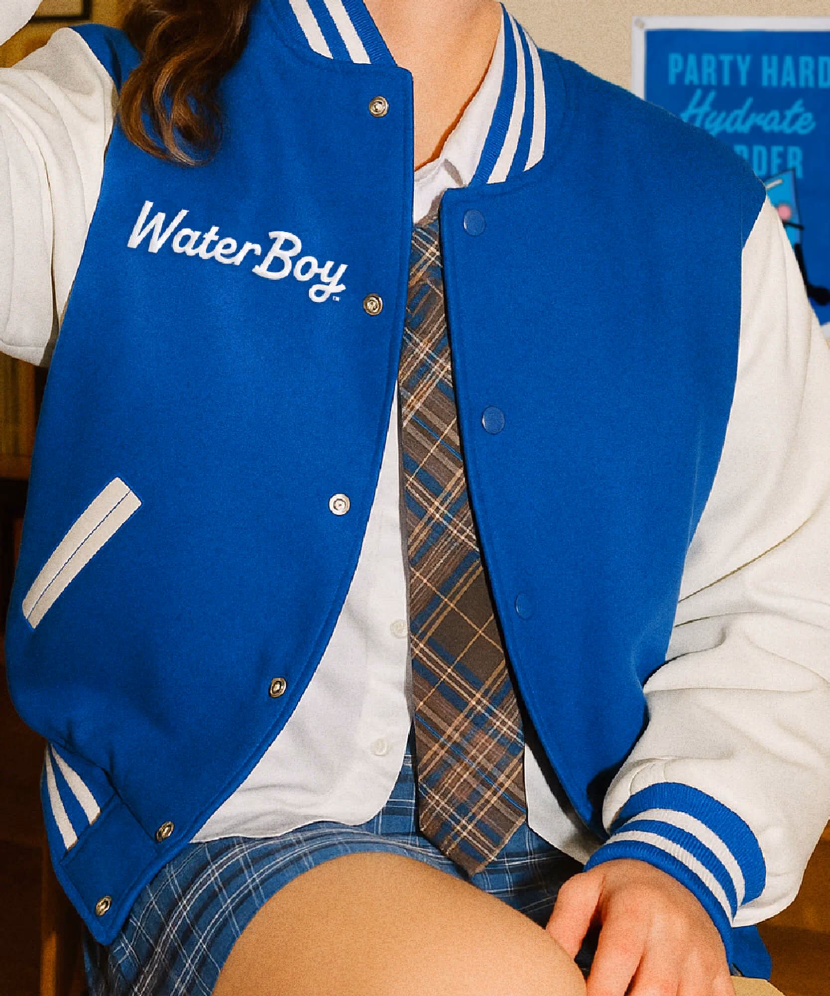 A person wears a royal blue WaterBoy varsity jacket with white trim and the brand name embroidered on the chest.