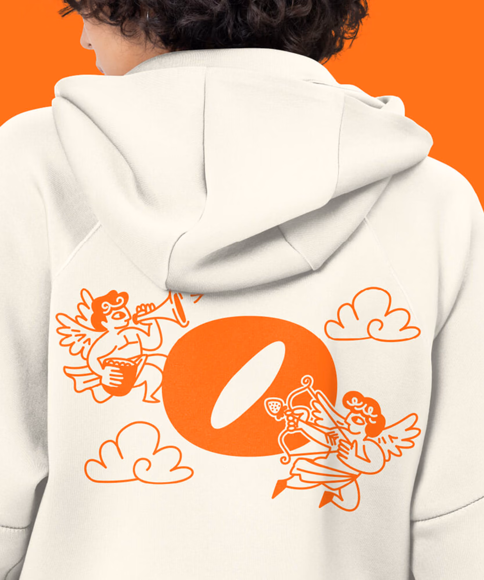 Back of a person in a cream Olyra hoodie with cherub illustrations; orange five-panel cap and blue 'Olyra' coffee cup.