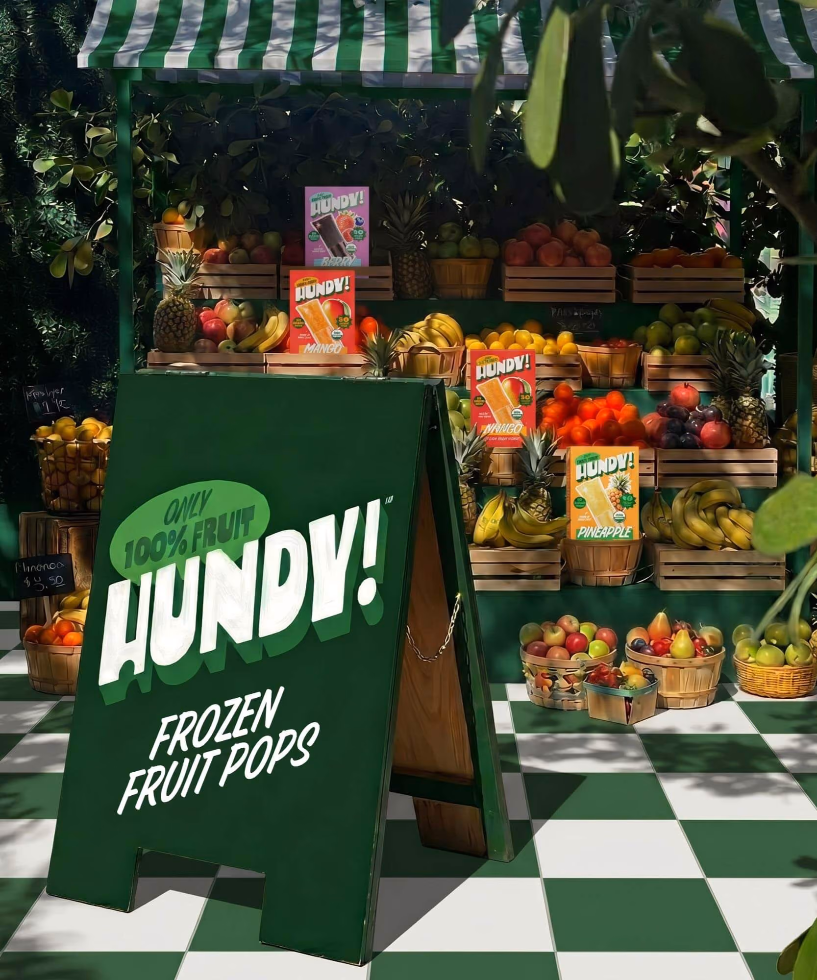 Produce-stand pop-up with a green A-frame sign reading "HUNDY! FROZEN FRUIT POPS" and cartons among bushel baskets