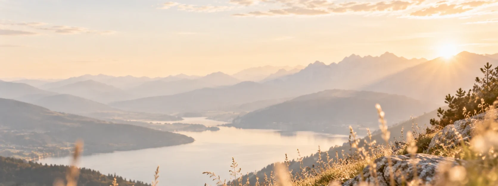 Weiter Blick über einen Bergsee im Morgenlicht