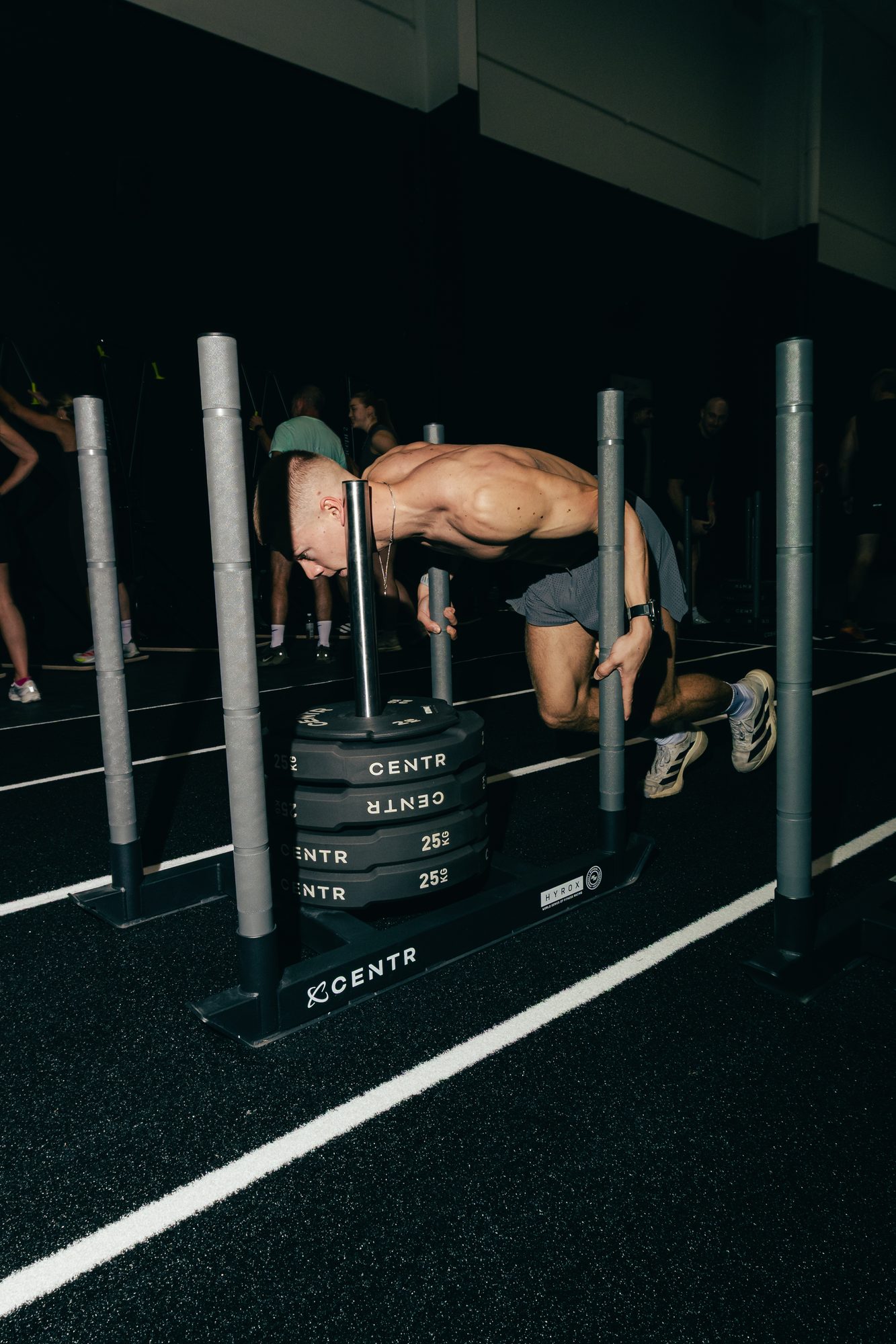 Athlete pushing a loaded CENTR sled down the 16m sled track at Atlas Training Club
