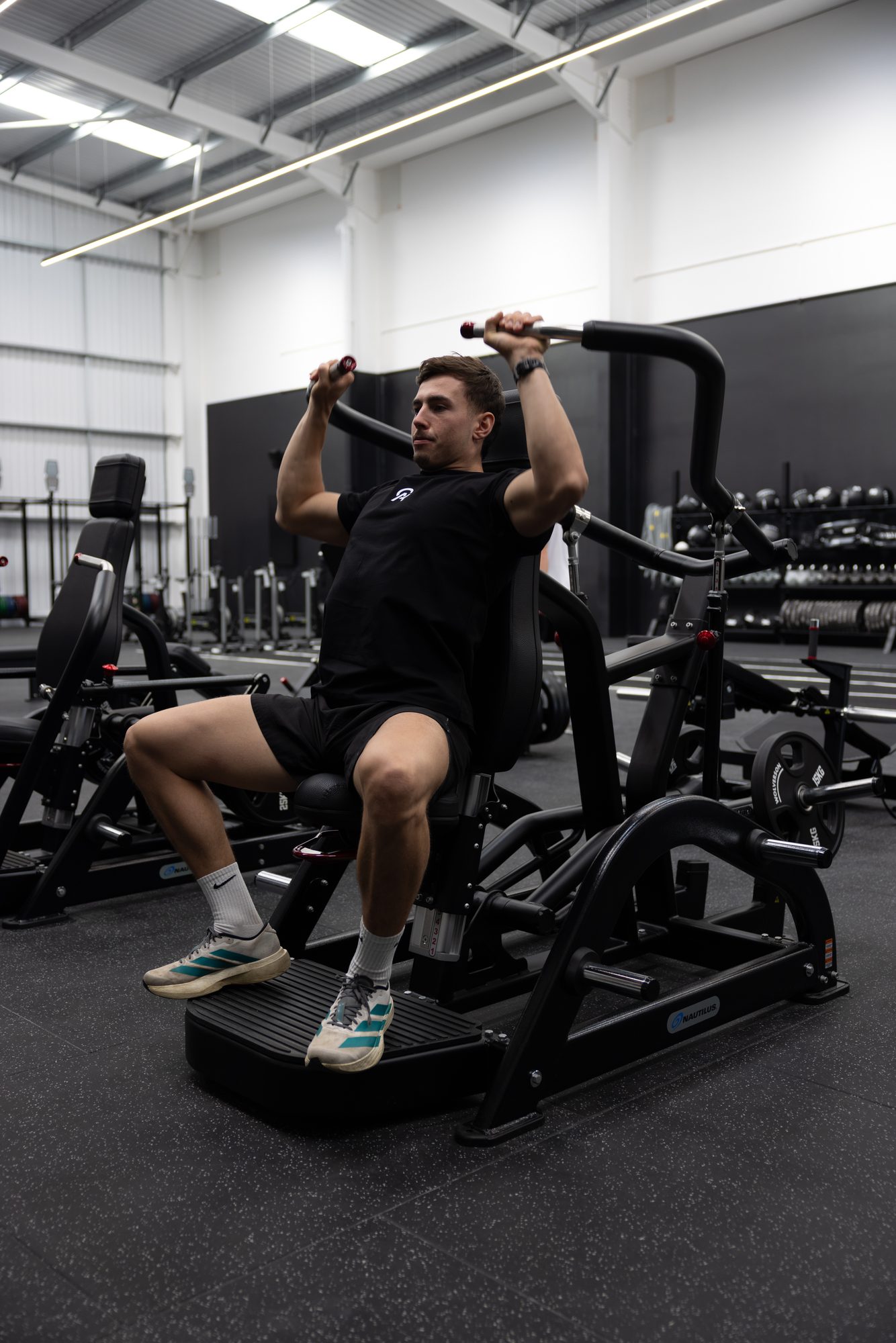 Member training on a Nautilus chest press in the strength zone at Atlas Training Club