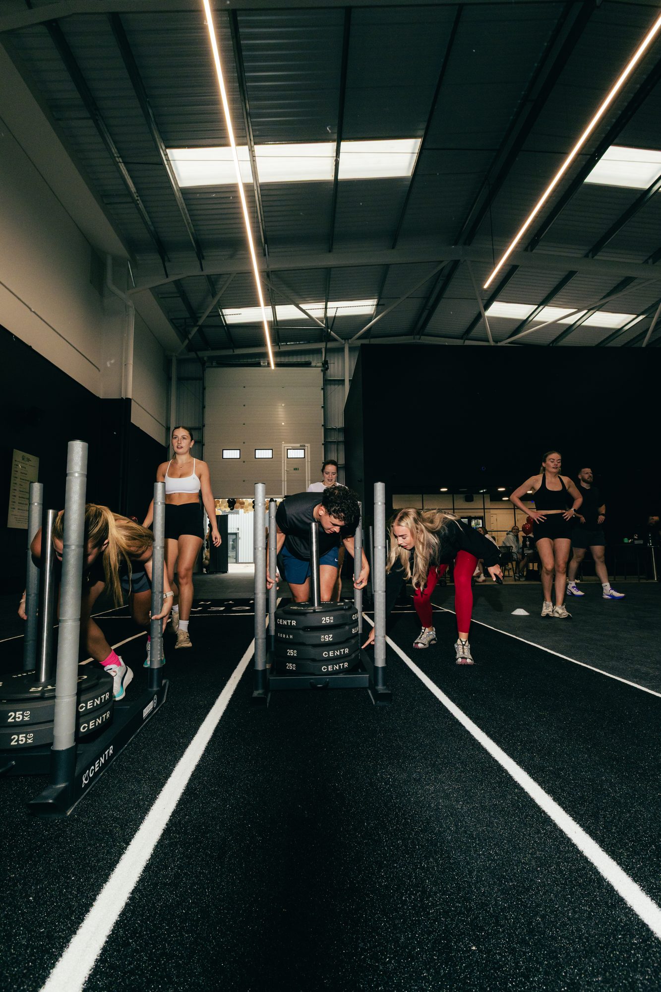 Members pushing CENTR sleds down the track during a HYROX group class at Atlas Training Club