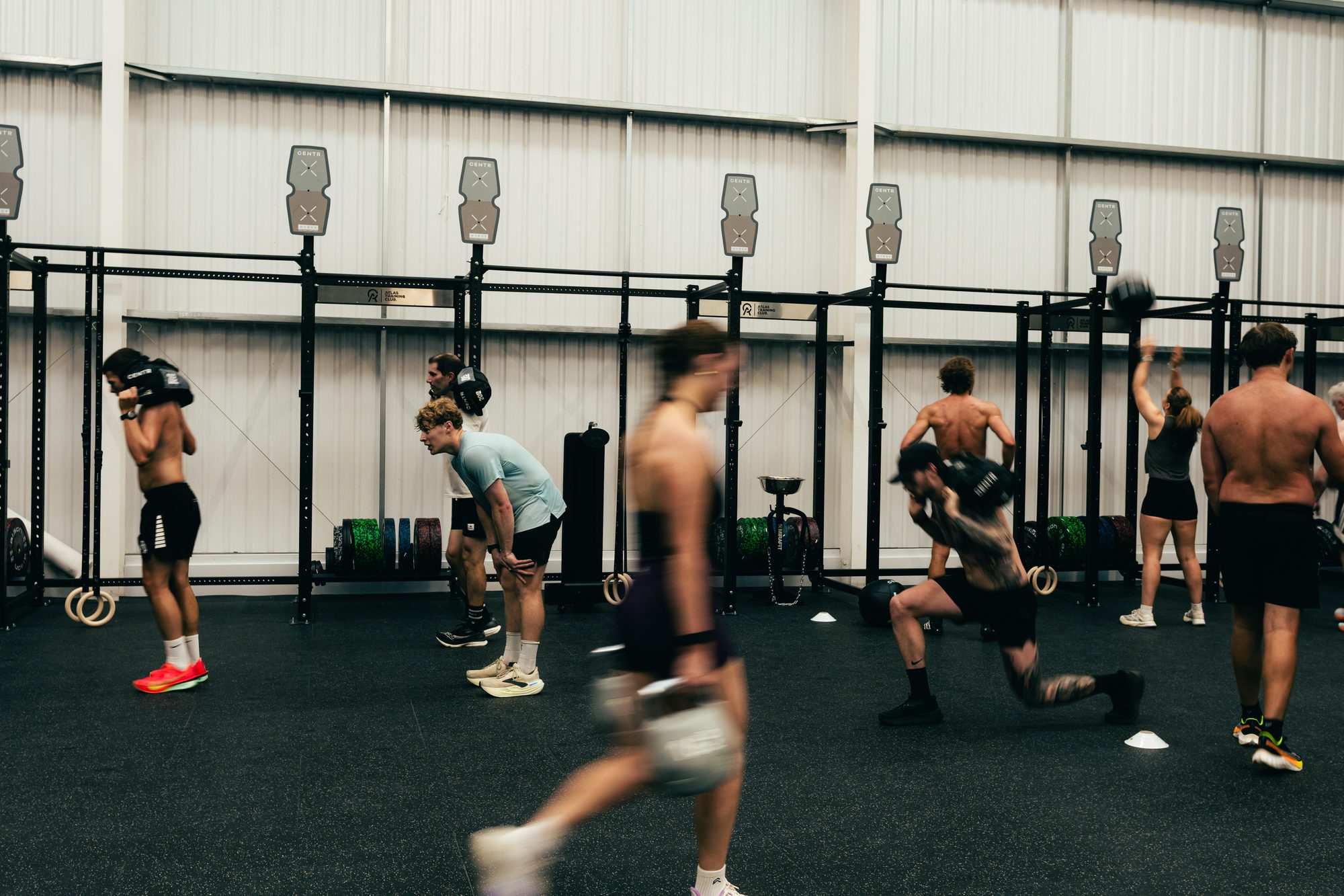 Members working through stations during a HYROX race simulation at Atlas Training Club