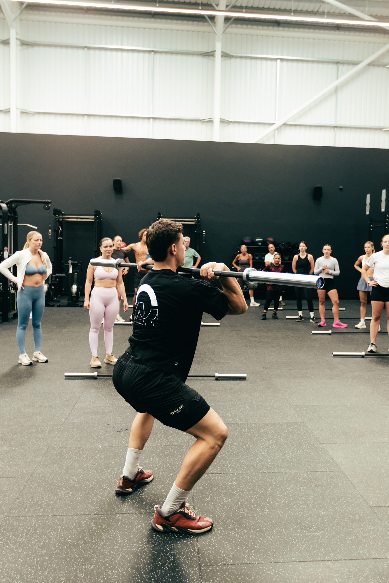 Coach demonstrating a front squat to a barbell class at Atlas Training Club, Adlington