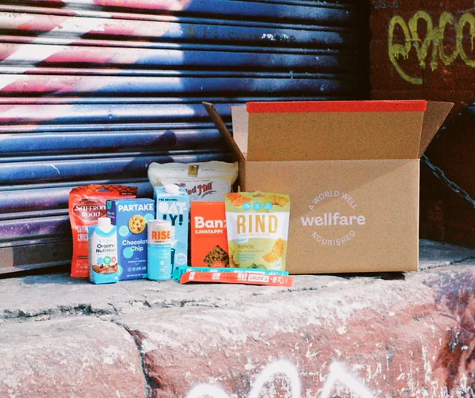 Wellfare Better Box of groceries on a stoop in front of a graffitied storefront