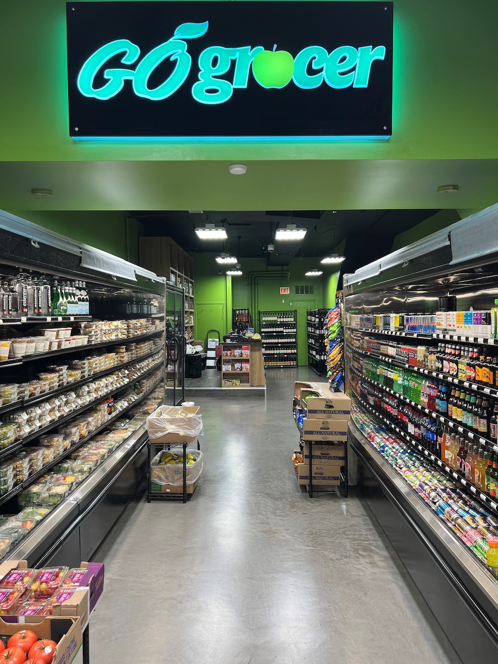 Go Grocer store interior with a neon sign above the aisles