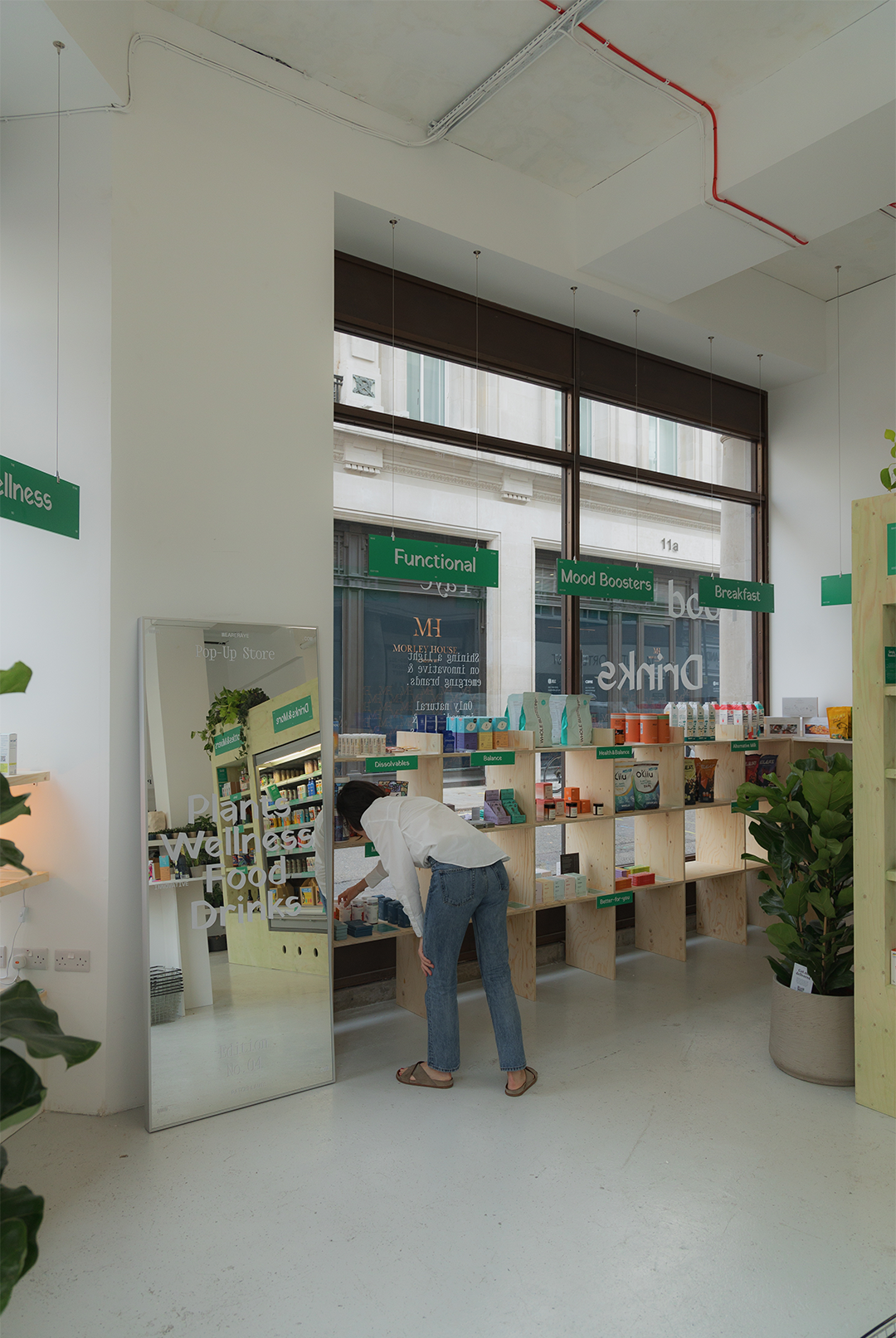 Nicole Compen restocking the plywood shelves inside the Raye pop-up store