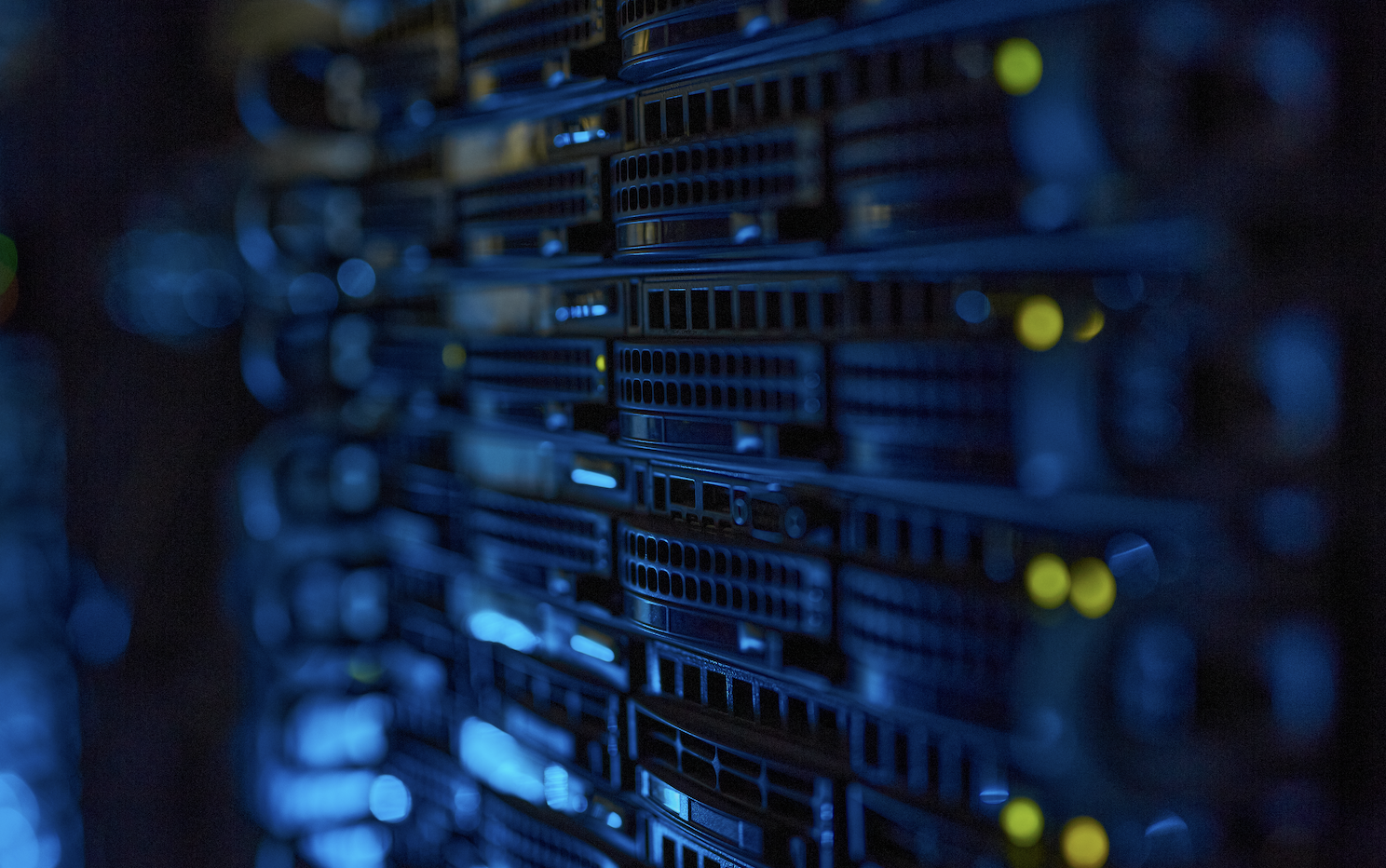 Close-up of server hardware racks with illuminated status lights in a dark data center.