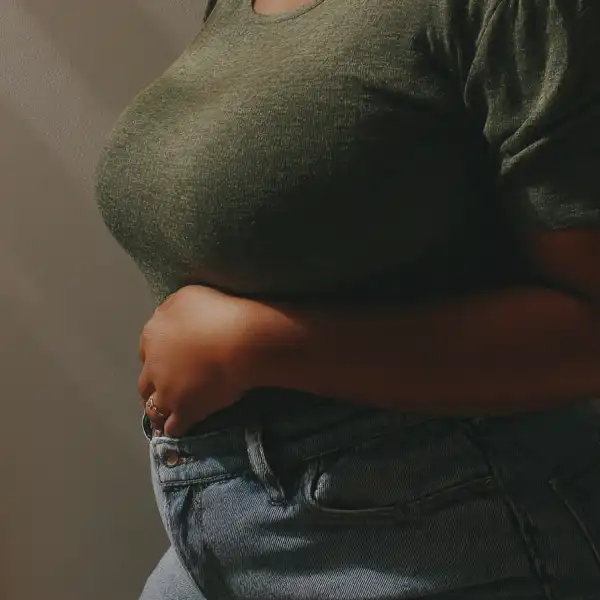 A plus-sized woman experiencing gut and GI side effects as a result of her GLP-1 prescription.