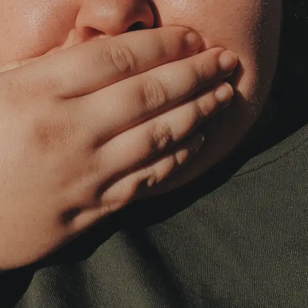 Plus-sized person dealing with sulfur burps as a result of GLP-1s.
