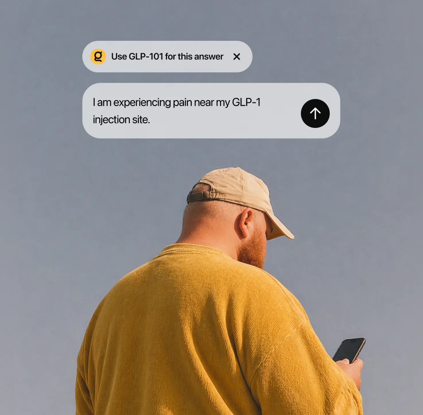 Man in yellow sweater and beige cap looking at phone with a chat message about GLP-1 injection pain.