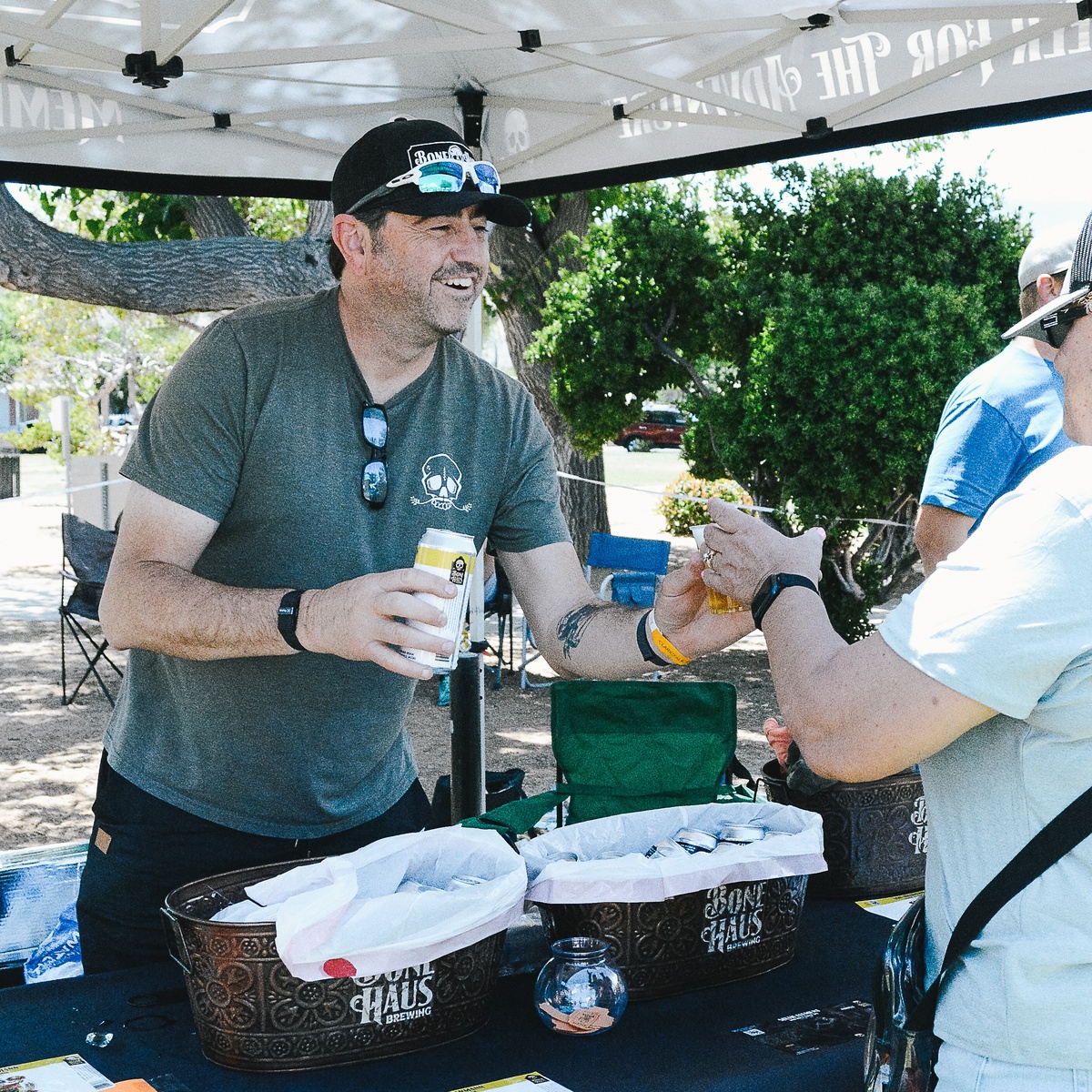 Keith Chapman, Bone Haus Founder and CEO, sharing beer with guests at an outdoor Bone Haus booth