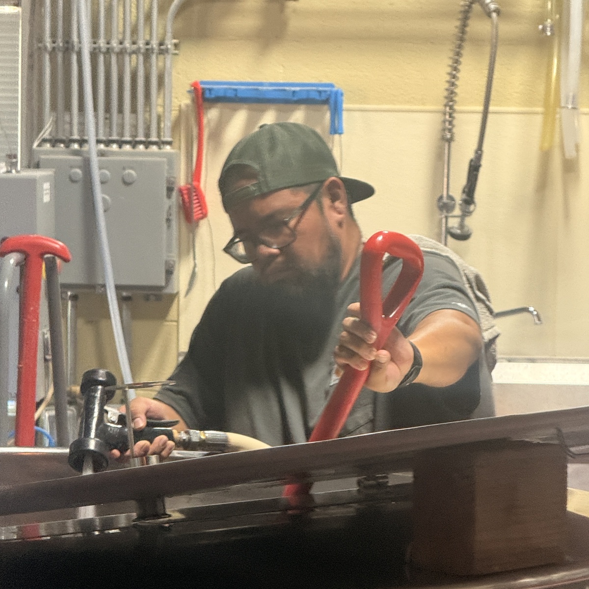 Jarrell Wauneka, Bone Haus Brewer, working with brewing equipment in the brewhouse