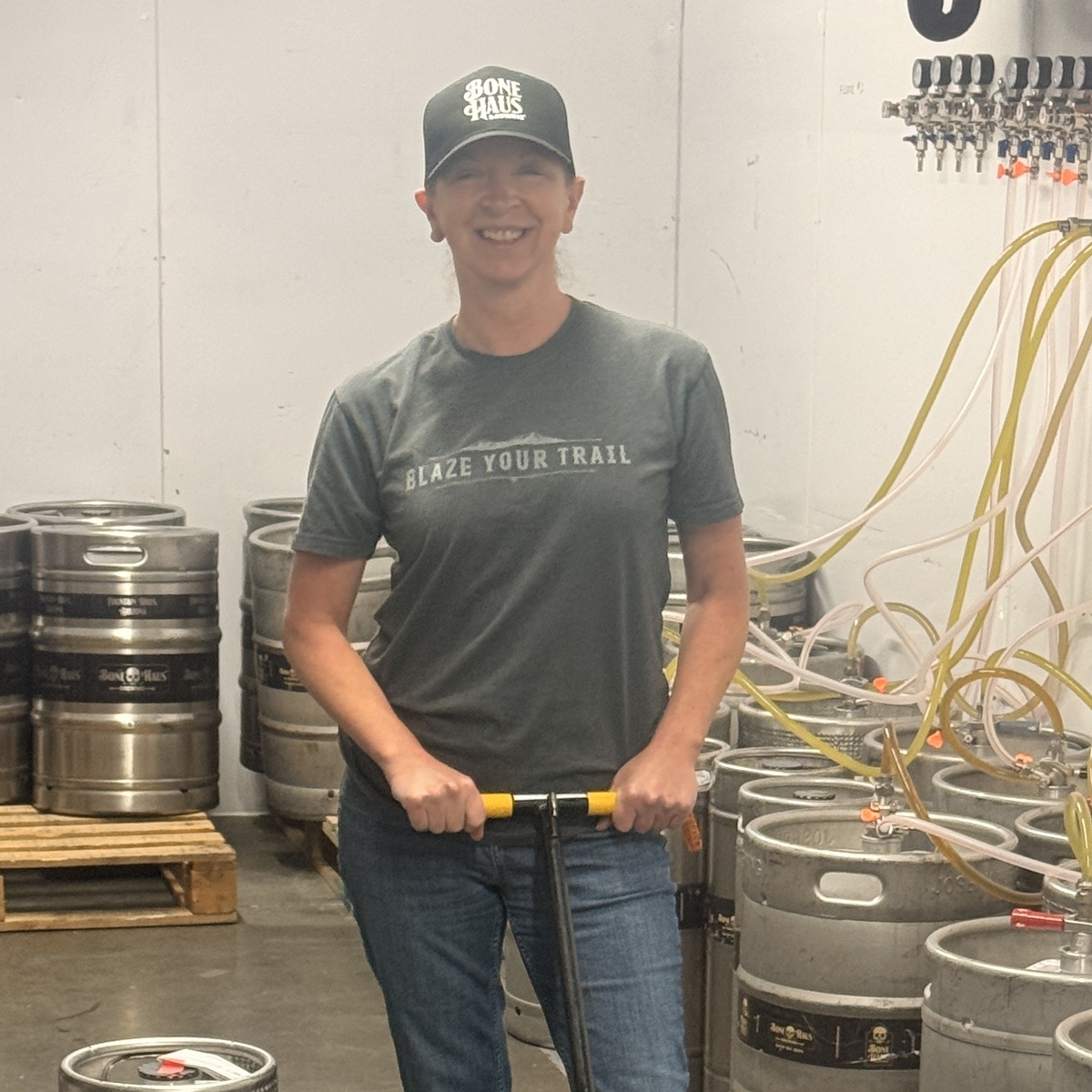 Jen Prenatt moving a keg among Bone Haus kegs in the brewery