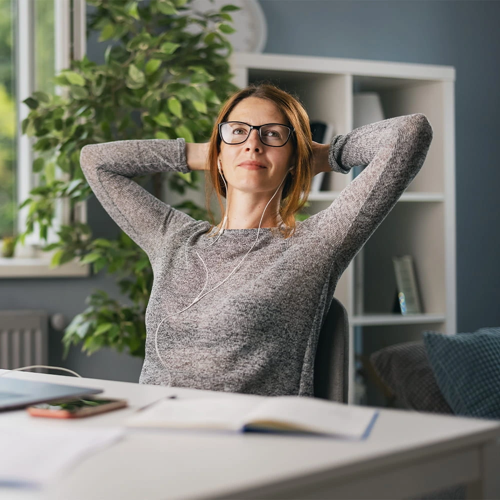 Unternehmerin entspannt am Schreibtisch zurückgelehnt - Website zum Festpreis erstellen lassen ohne Technik- oder Designstress