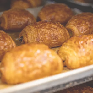 Golden brown freshly baked croissants on a baking tray.