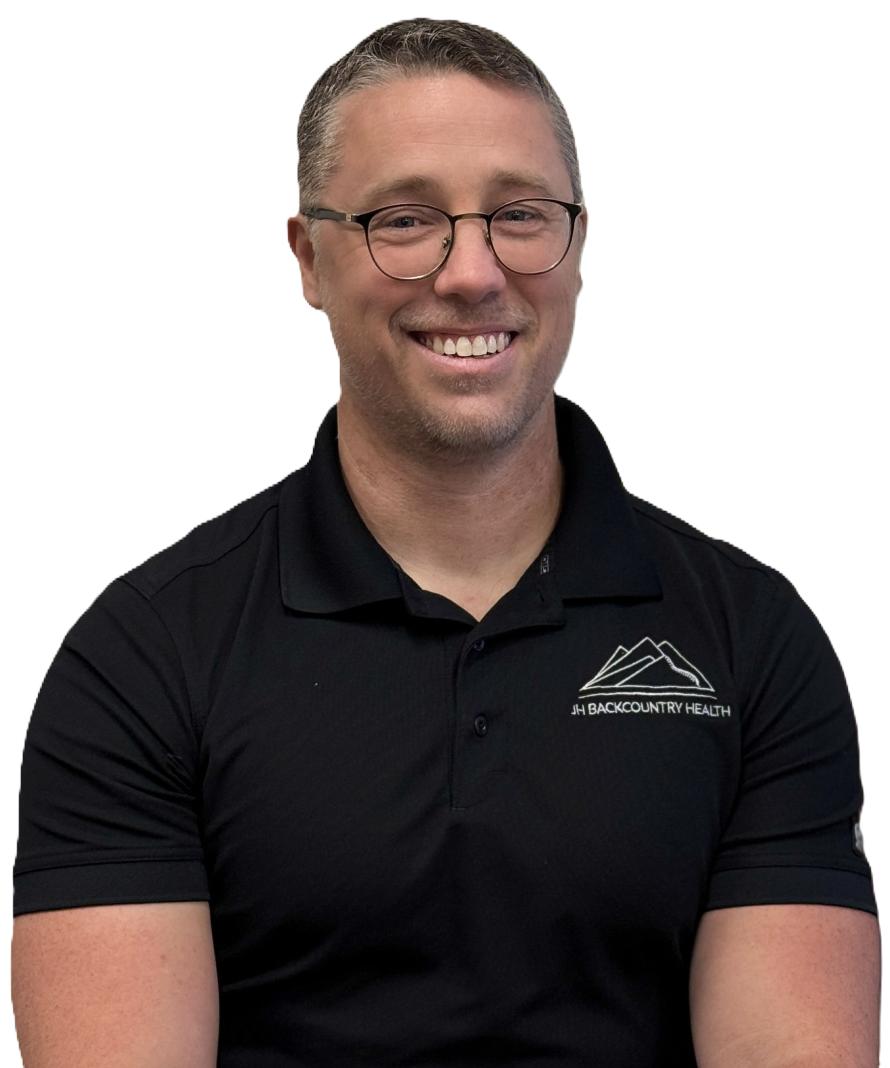 Smiling man wearing glasses and black polo shirt with JH Backcountry Health logo.