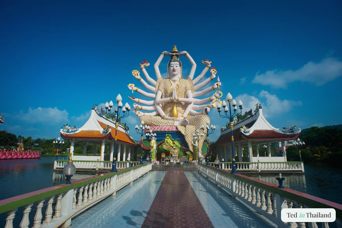 The white 18-armed Guanyin statue at Wat Plai Laem reflected in the temple lake on Koh Samui