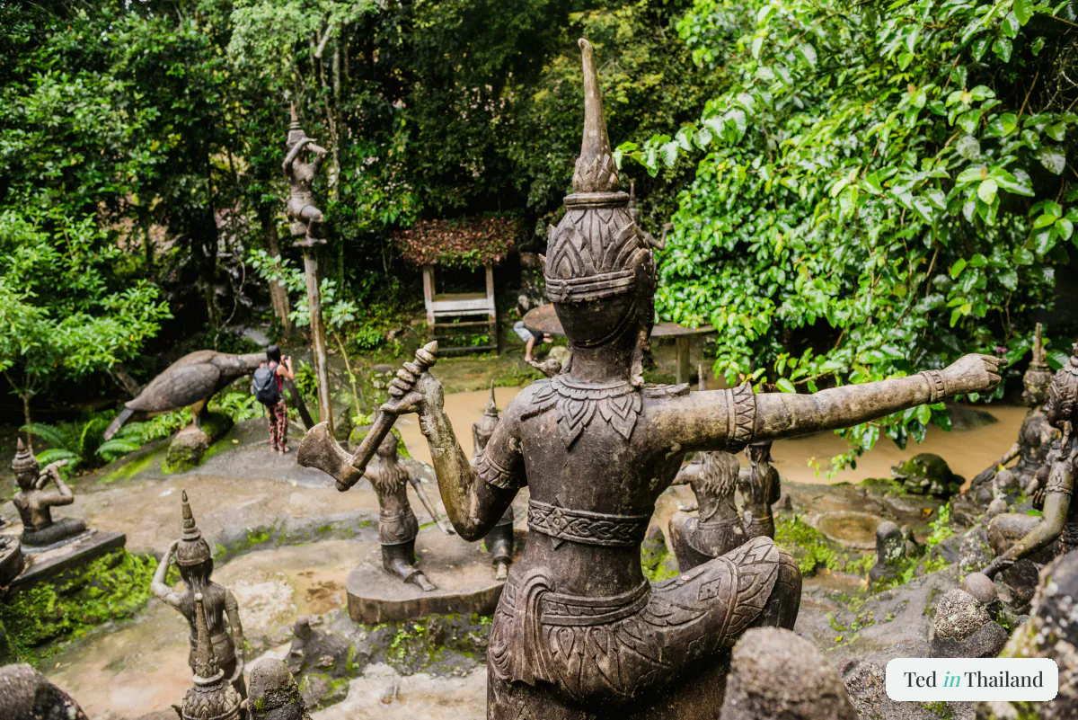 Weathered stone statues arranged in a jungle clearing at the Secret Buddha Garden on Koh Samui