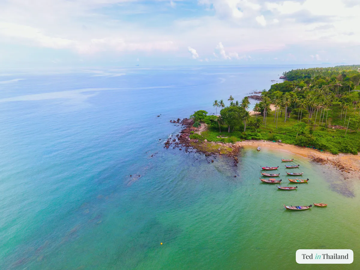 Calm Koh Samui coastline and forested islet under a wide tropical sky, showing the best time to visit Koh Samui