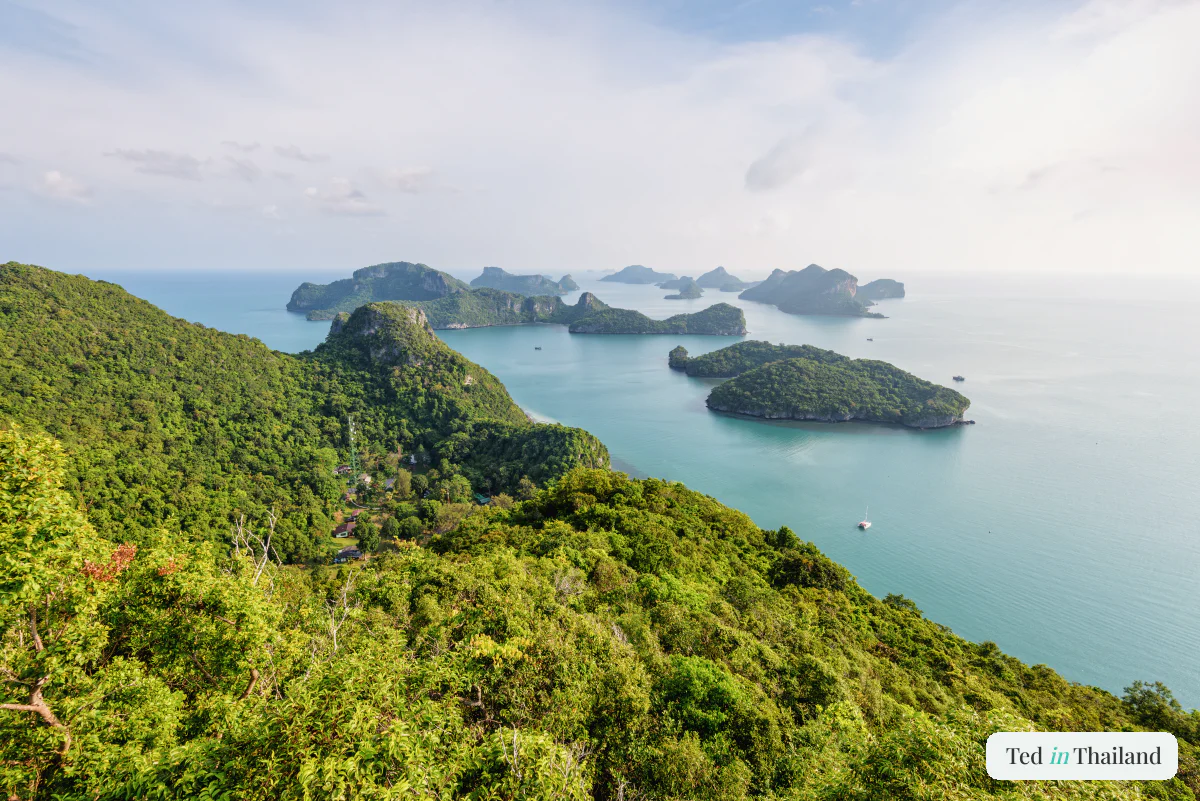 A high viewpoint over the forested limestone islands of Ang Thong National Marine Park scattered across the sea