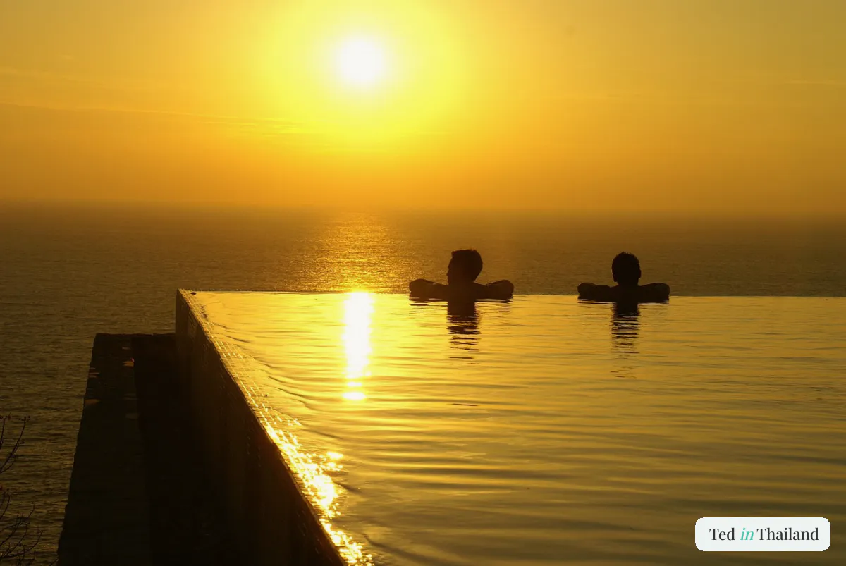 Couple in an infinity pool watching the sunset at a honeymoon resort in Koh Samui