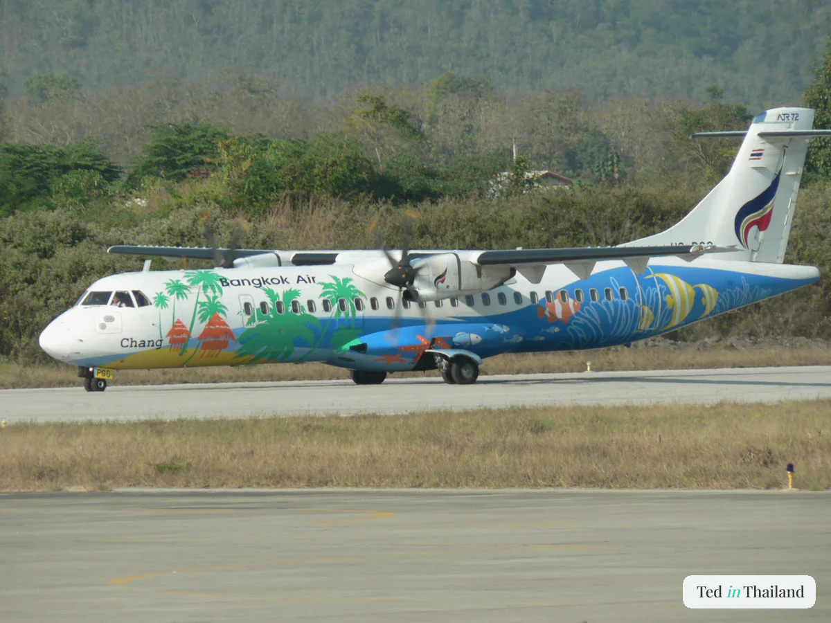 A Bangkok Airways ATR 72 turboprop on the tarmac at Koh Samui Airport (USM) with green hills behind