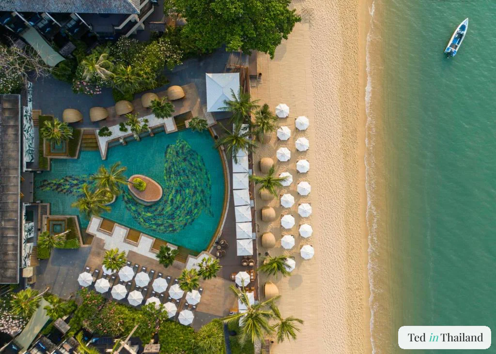 Aerial view of the lagoon pool, thatched cabanas and beach umbrellas at Anantara Bophut on Bophut Beach, Koh Samui