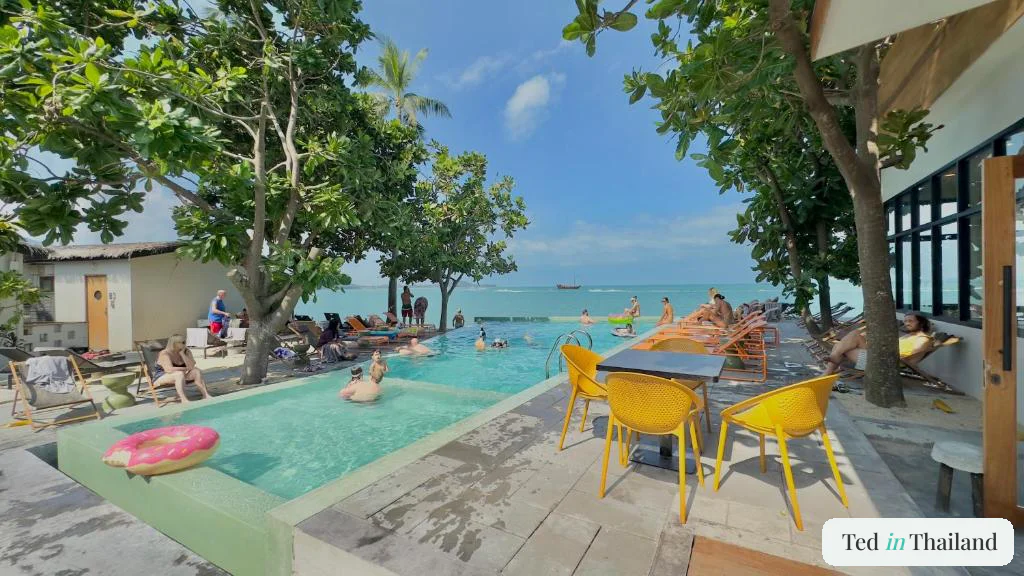 Guests by the beachfront pool at Escape Beach Resort in Maenam, a top-value mid-range resort in Koh Samui