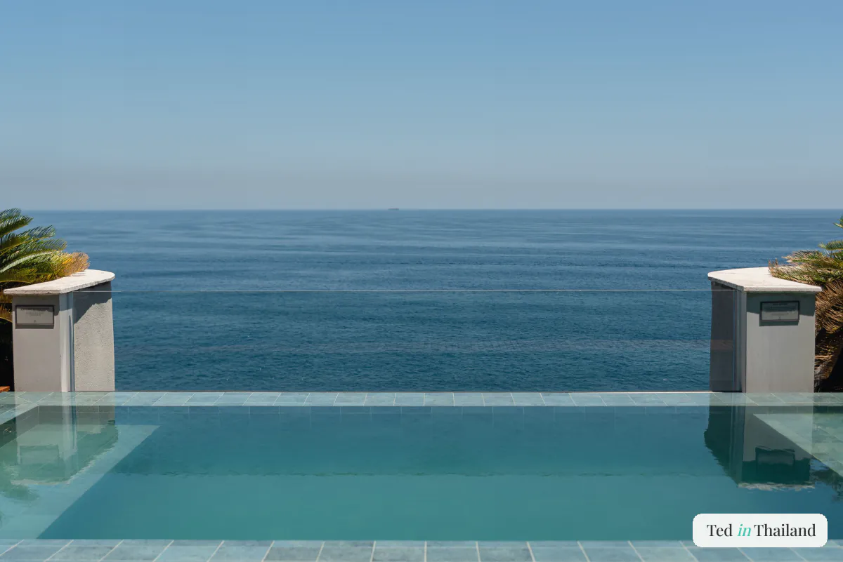 Tiled infinity pool at a luxury private villa on Koh Samui overlooking the open sea, framed by palms