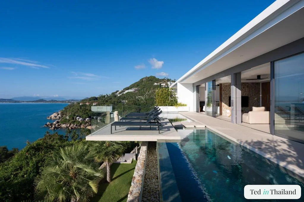 Contemporary white villa at Sukkho Samui Estates with a long cantilevered infinity pool above the bay