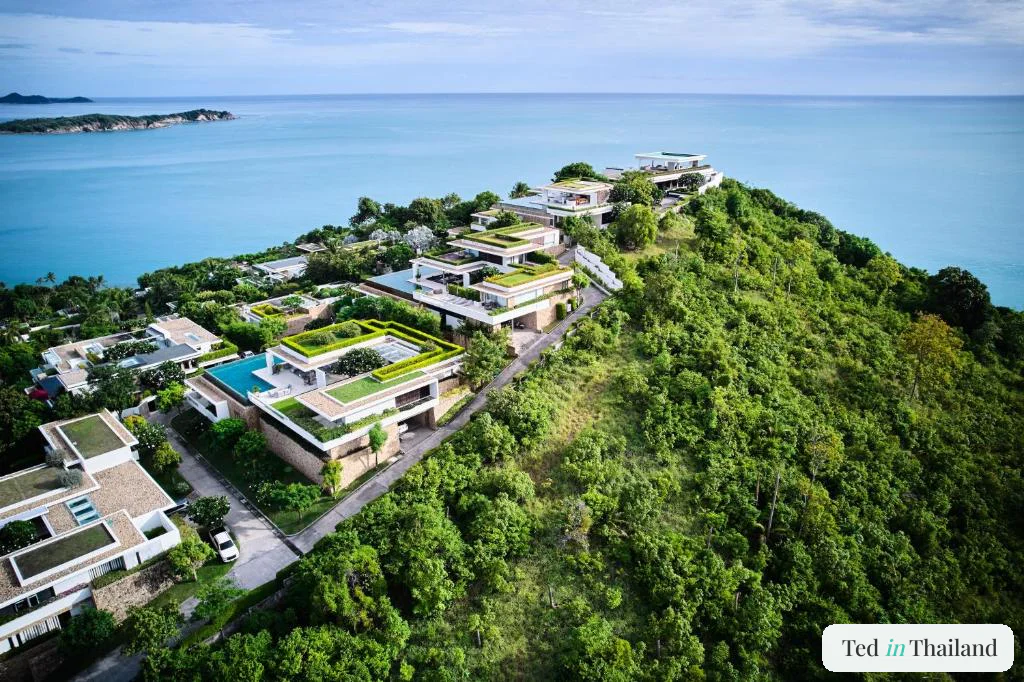 Aerial view of contemporary green-roofed Samujana villas stepping down a forested headland on Koh Samui