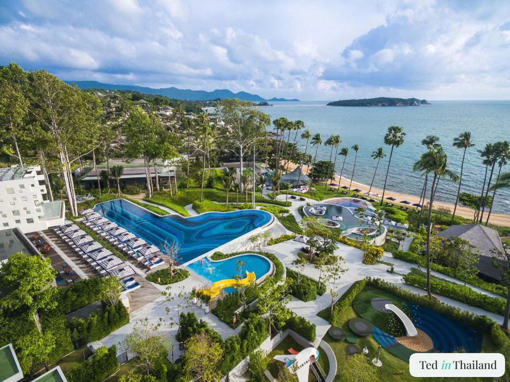 Aerial view of the yellow waterslide, kids club and lagoon pools at Hyatt Regency Koh Samui near Chaweng Noi beach