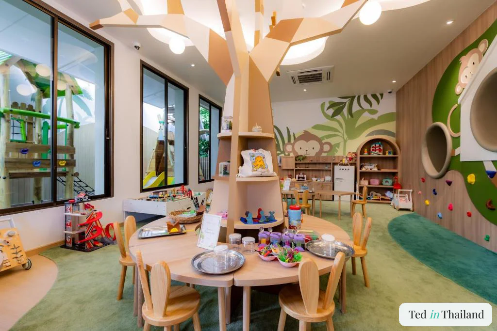 Indoor kids club with a sculptural timber tree and jungle mural at Anantara Bophut, a family resort on Bophut Beach