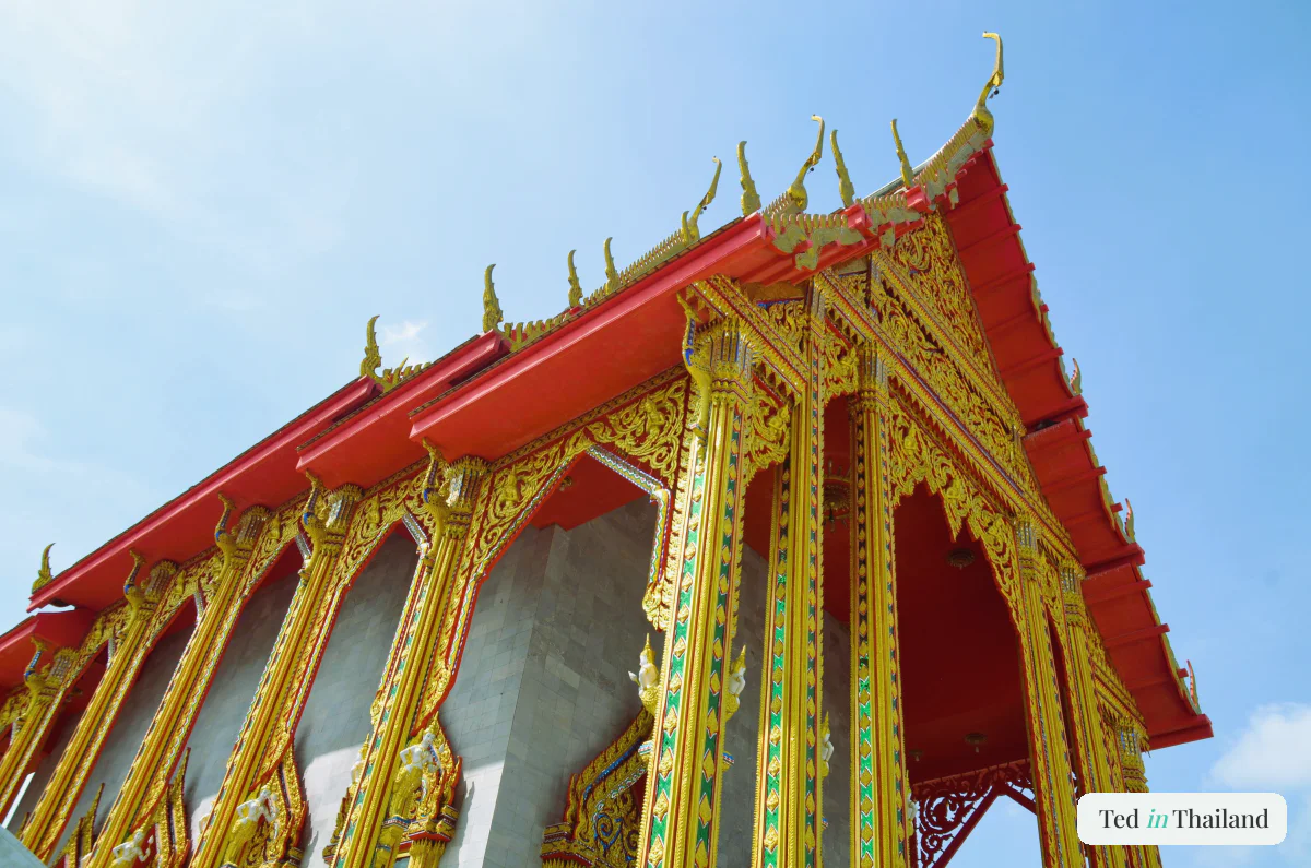 Red-and-gold tiered temple roof with naga gables on Koh Samui, where modest dress and temple etiquette apply