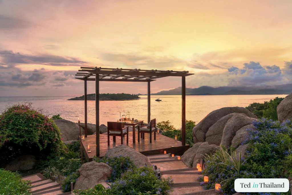 Candlelit private dining deck on granite boulders at sunset at Six Senses Samui, fine dining on Koh Samui