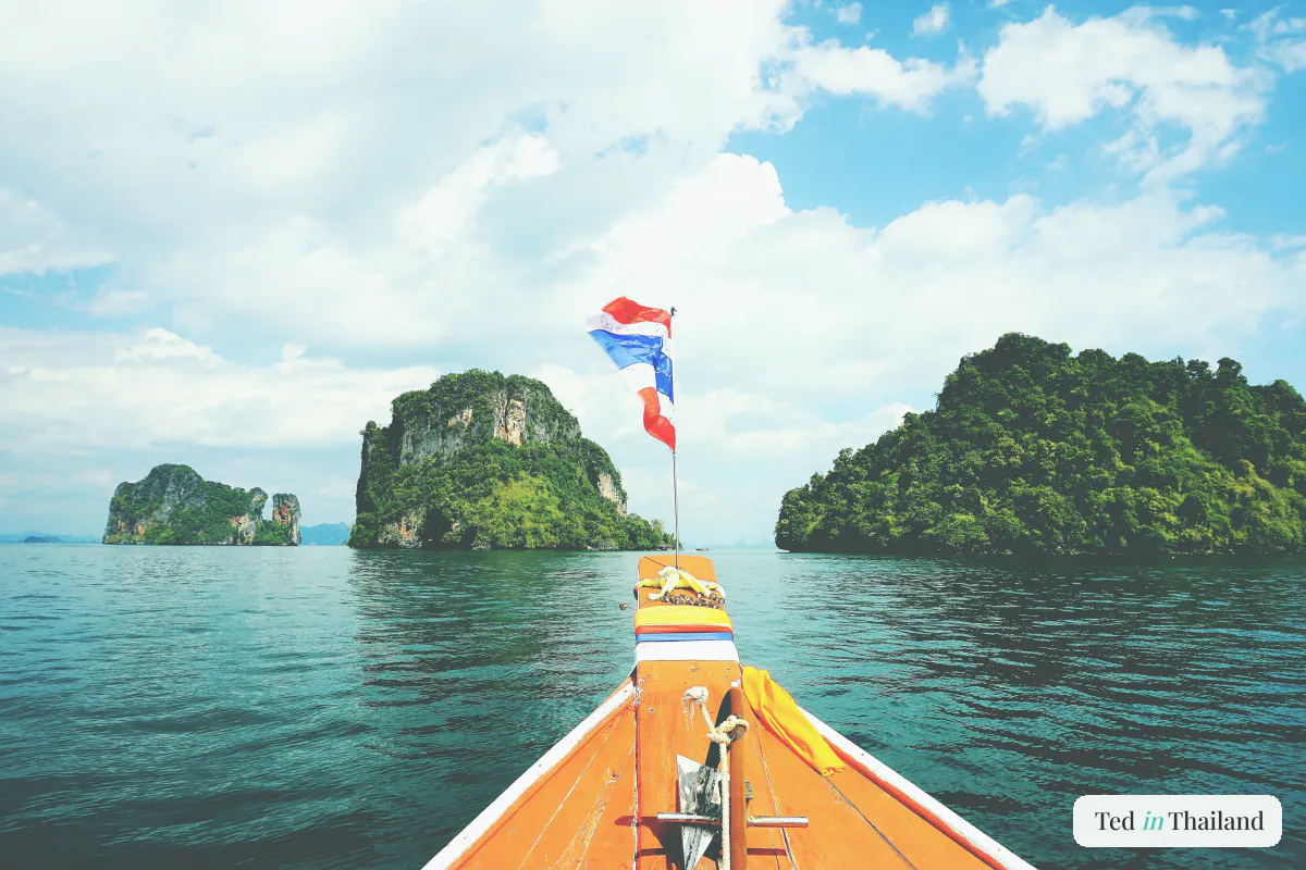 Bow of a Thai longtail boat heading toward jungle-topped islands on a snorkeling trip from Koh Samui