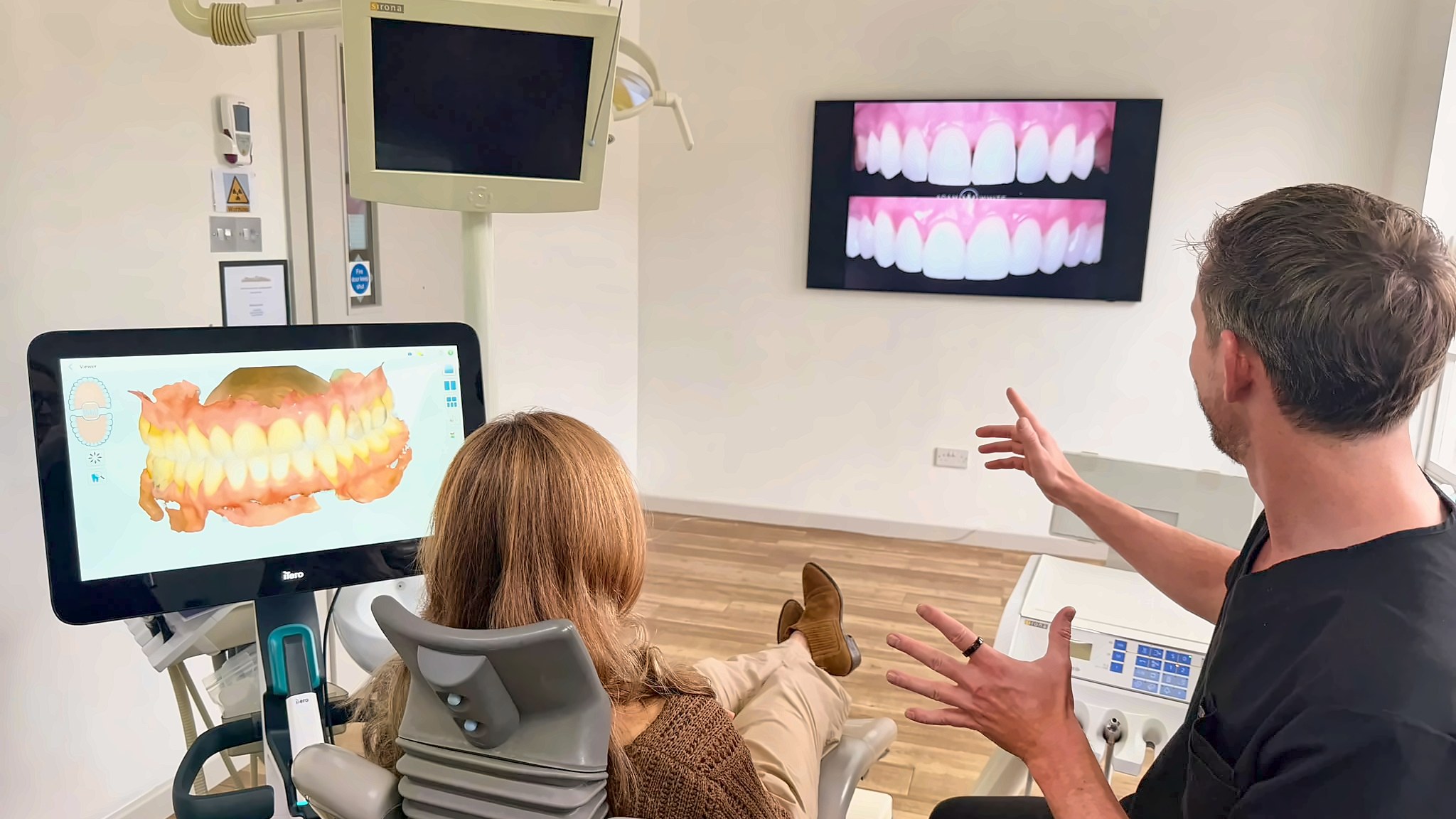 Dr Adam White talking through a digital scan with a patient at Bellevue Dental