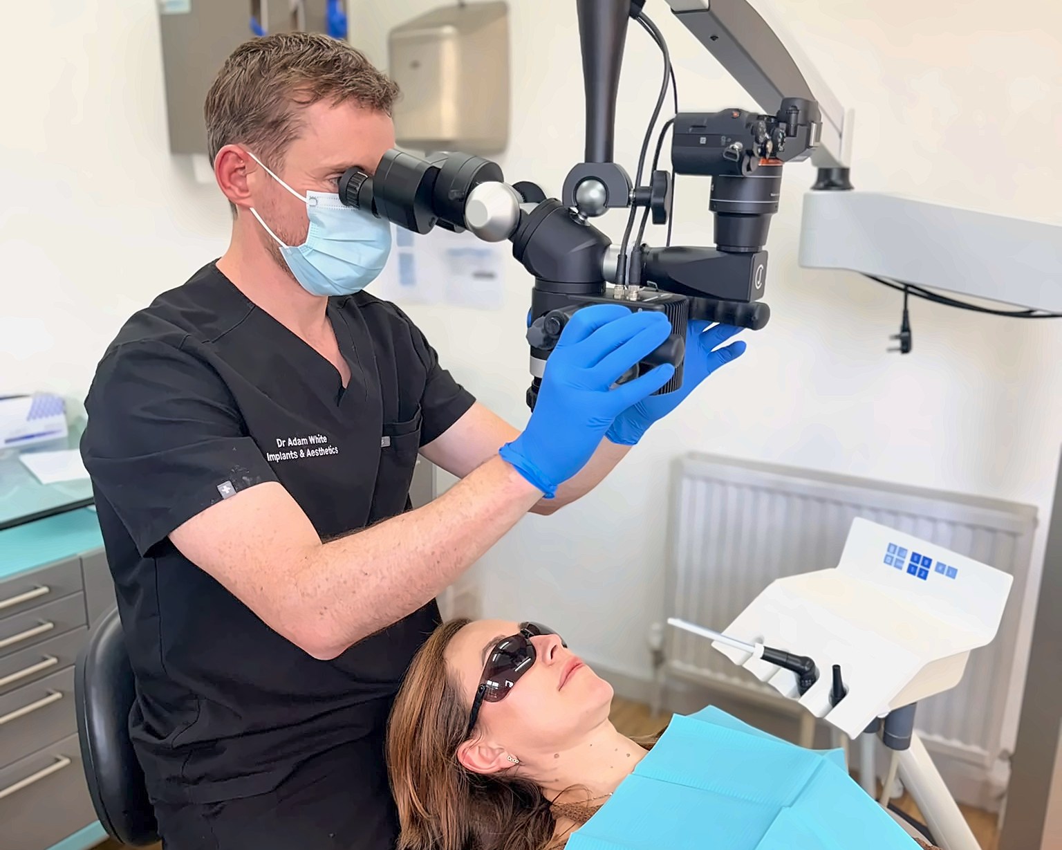 Dr Adam White examining a tooth under the operating microscope at Bellevue Dental