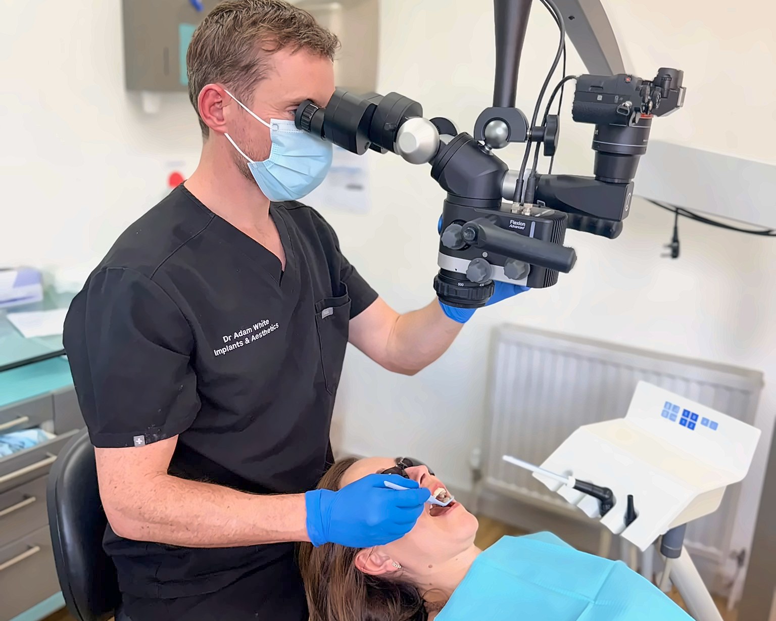 Dr Adam White treating a patient under the operating microscope at Bellevue Dental