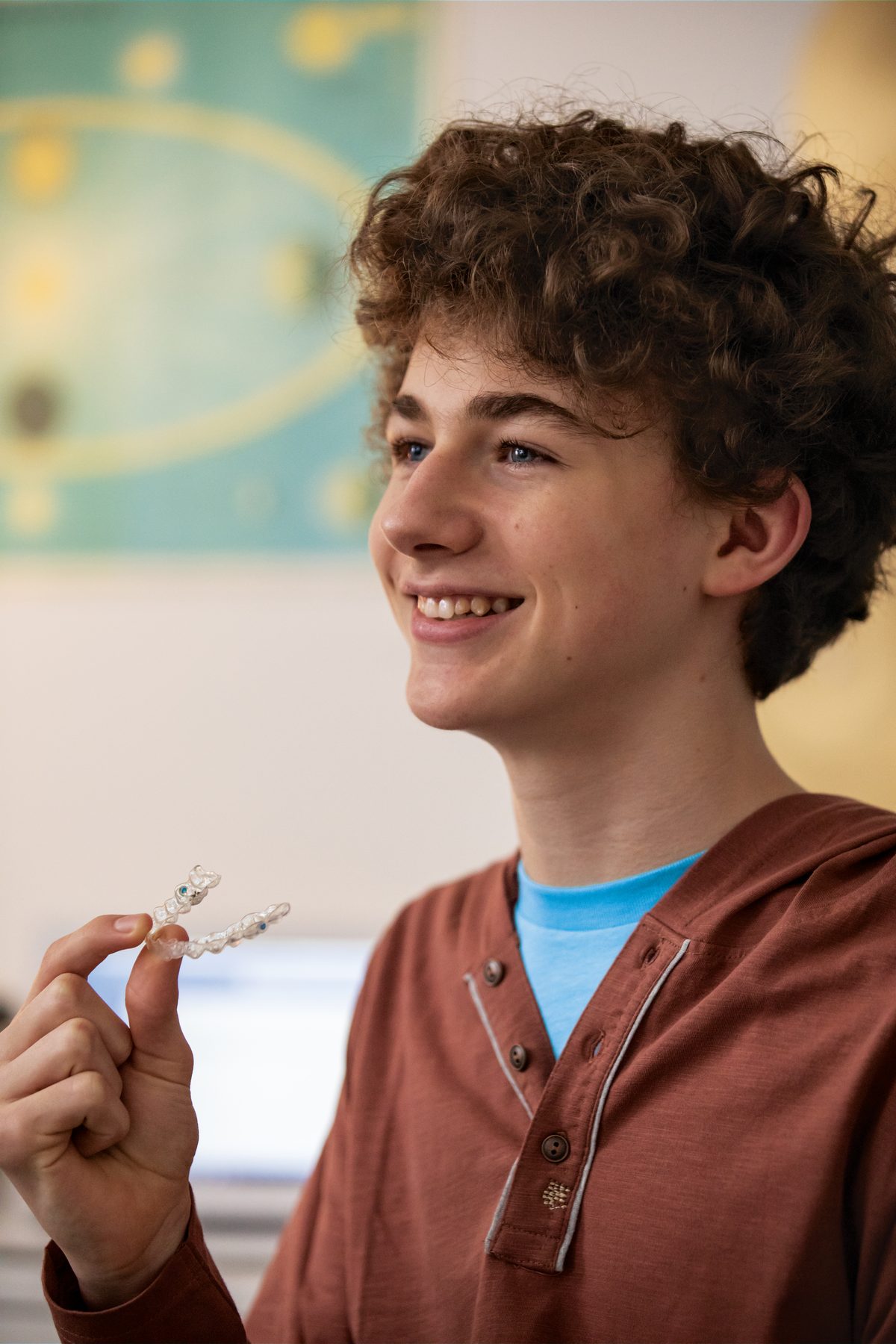 A teenager smiling while wearing Invisalign® clear aligners