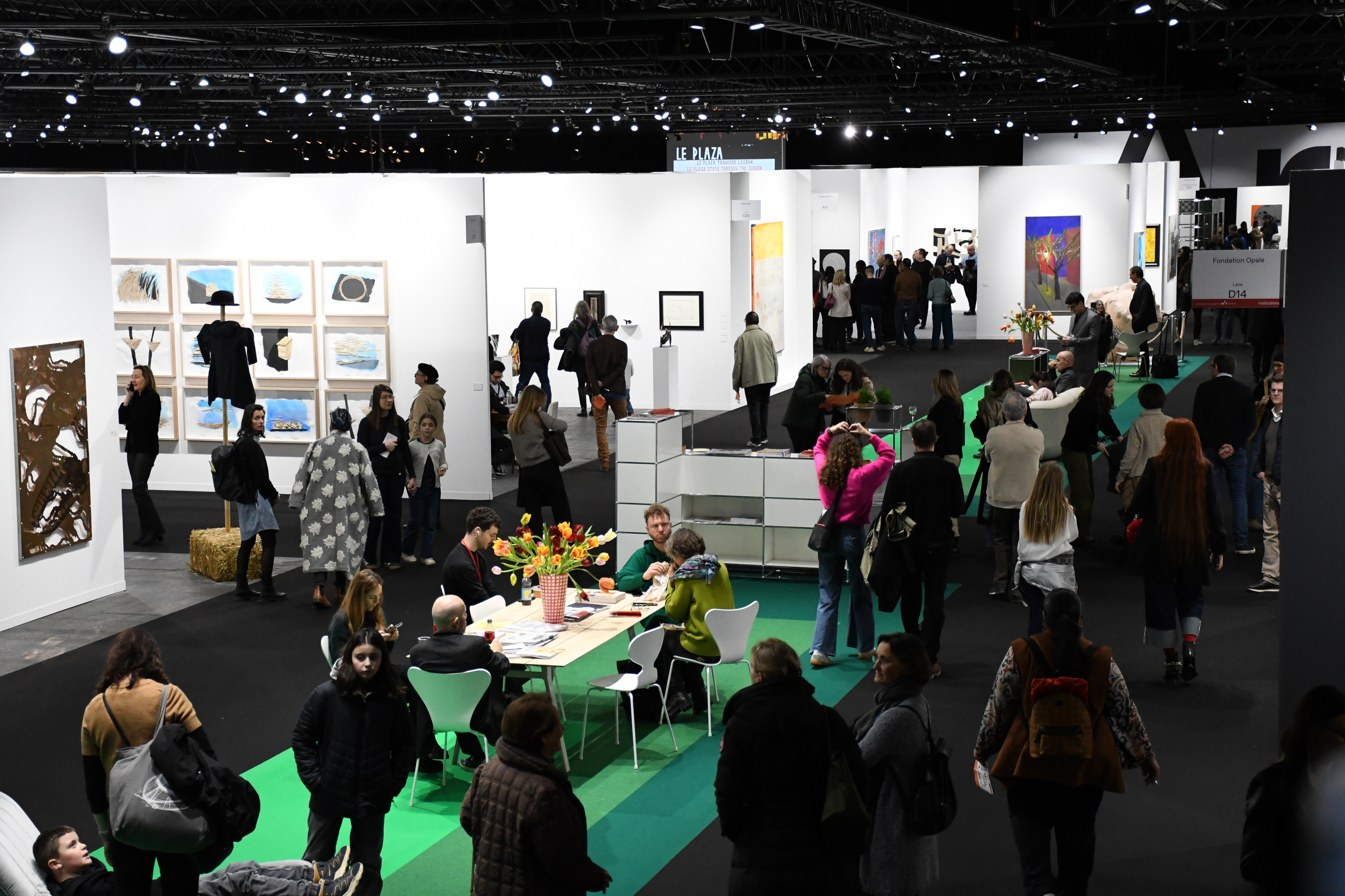 A woman poses for a professional portrait sitting on a red couch in a hotel lobby. 