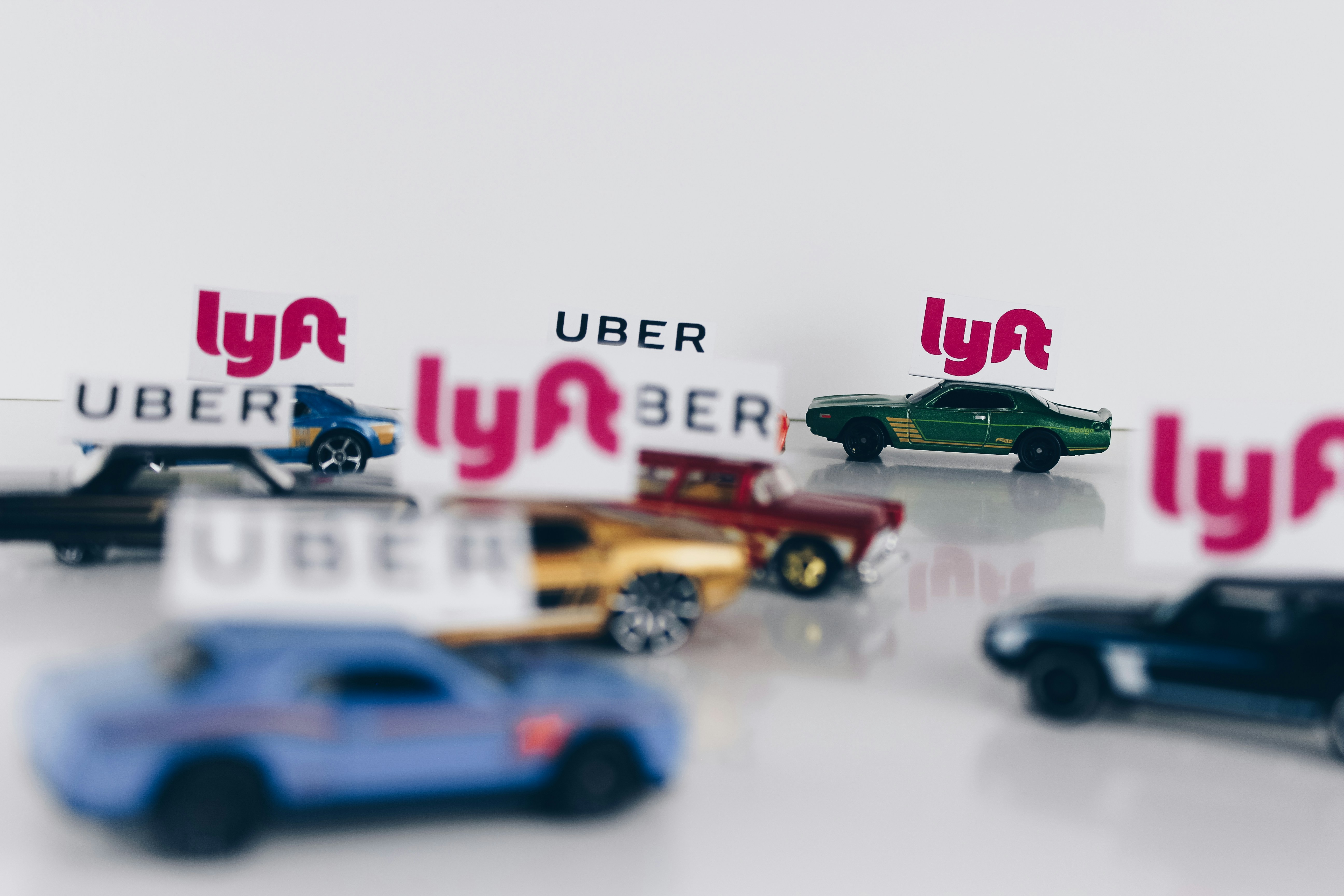 mini cars with the uber's, lyft's brands logo on it 
